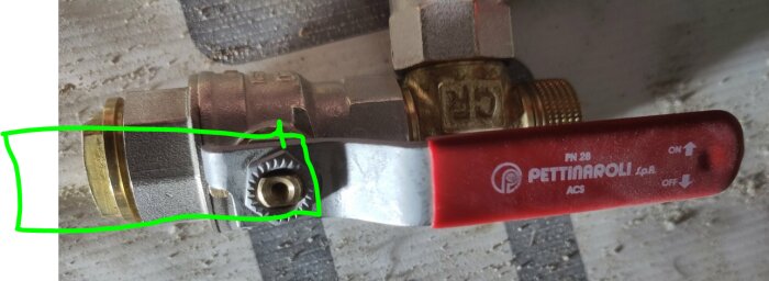En röd ventilhandtag märkt "Pettinaroli" monterad på mässingsrör, med gröna markeringar kring en ledning.