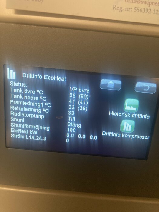 Digital display visar information för värmesystem: temperaturer, pumpstatus och elförbrukning, troligen för en värmepump.