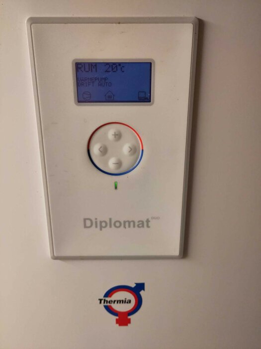 Termostat med display visar rumstemperatur 20.2°C, varmepump auto, knappar för justering, märke "Thermia".