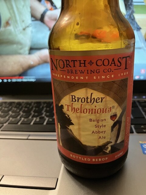 En ölflaska från North Coast Brewing, Brother Thelonious belgisk stil, framför en bärbar dator.