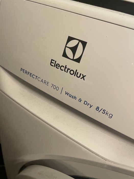 Vit Electrolux tvättmaskin, PerfectCare 700, tvätt och tork 8/5 kg, närbild, del av maskin.