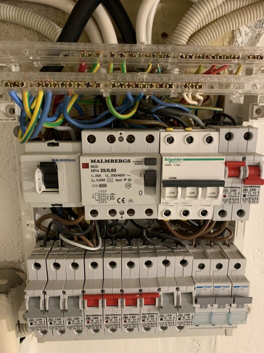 Elcentral med säkringar, jordfelsbrytare, kablar, märkt med "Malmbergs" och "Schneider Electric".