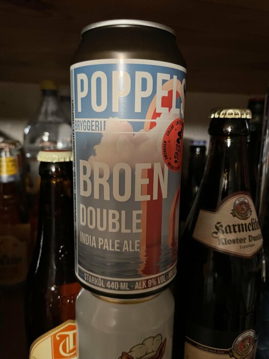 Ölburk märkt "Poppels Bryggeri Broen Double India Pale Ale", 9% alkohol, omgiven av andra drycker.