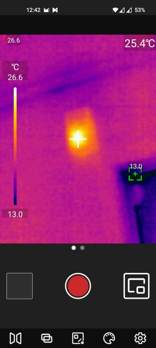 Värmekamera visar temperaturfördelning, varmt objekt i mitten, färgskala, mobilskärmsgränssnitt.