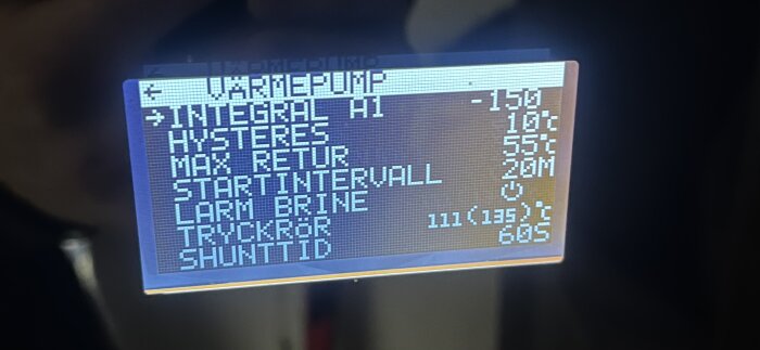 Digital display visar tekniska parametrar för möjligtvis en värmepump eller liknande system. Innehåller värden och enheter.