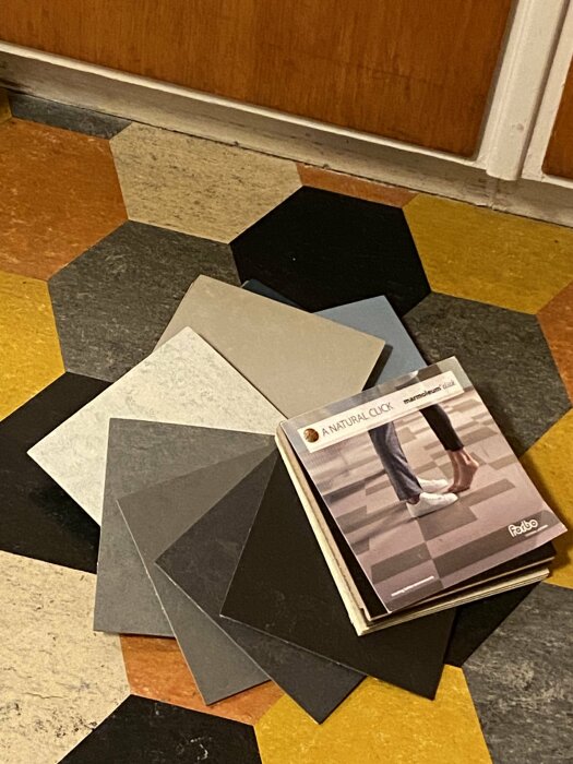 Färgprov och katalog på golv med hexagonala plattor. Inredningsförberedelse eller renoveringsplanering.