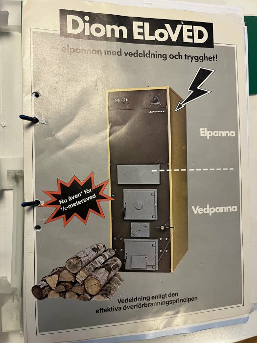 Affisch för Diom ELoved, en elpanna, med illustration på vedpanna och vedträn. Texten lyder "Nu även för 1/2-metersved".