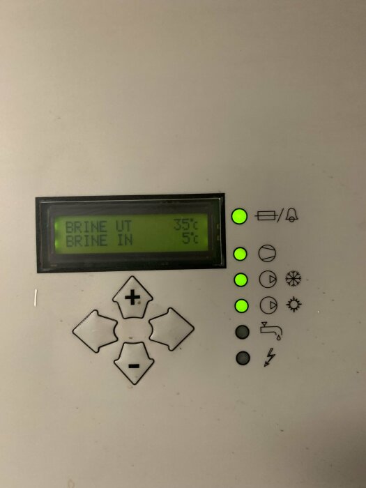 Digital panel med temperaturvisning och styrknappar omgiven av statusindikatorlampor på en apparat.