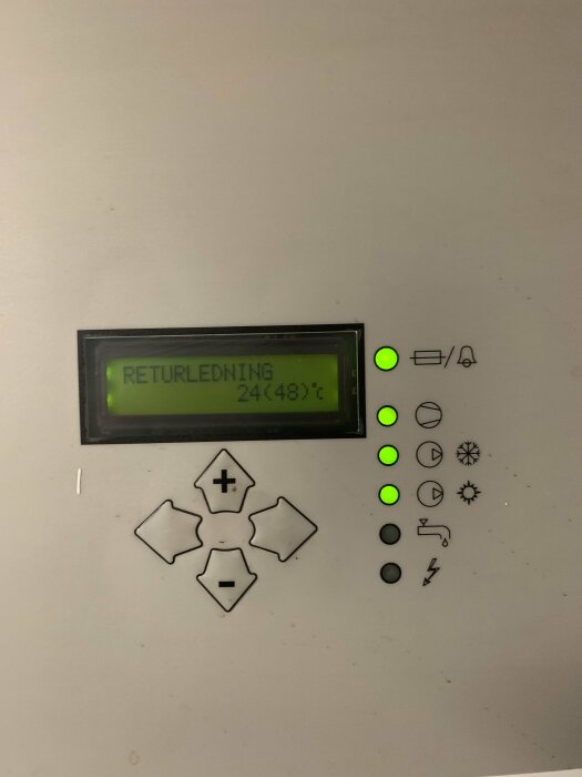 Kontrollpanel med LCD-display visar "RETURLEDNING 24.48°C" och gröna indikatorljus aktiva.
