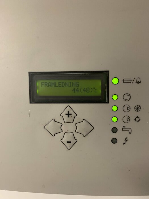 Display på kontrollenhet visar "FRAMLEDNING 44(48)°C", omgivet av knappar och statusindikatorer, troligen för värmesystem.