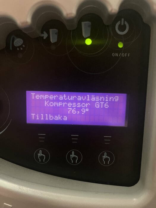 Digital display för temperaturövervakning med knappar och indikatorlampor på en apparat eller maskin.