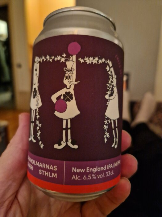 Burk med tecknad figur, New England IPA, 6,5% alkohol, lila färgschema, hand håller den.