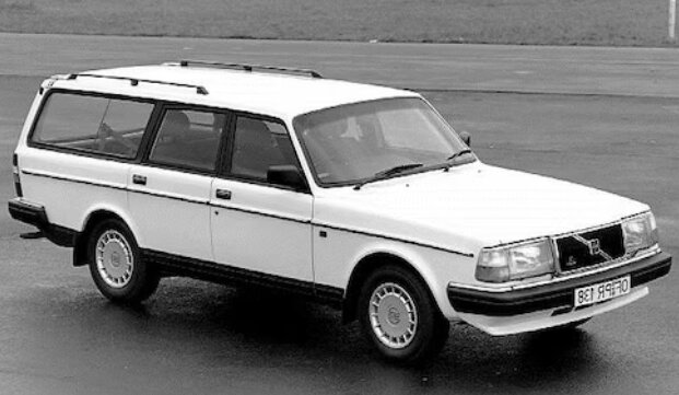 Svartvit bild av klassisk kombi-modellbil, troligen 1980-tals, parkerad på en tom yta.