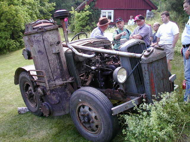Gammal traktor, flera personer i hattar, landsbygdsmiljö, sommar, betraktande, grupp, samlas kring fordon.