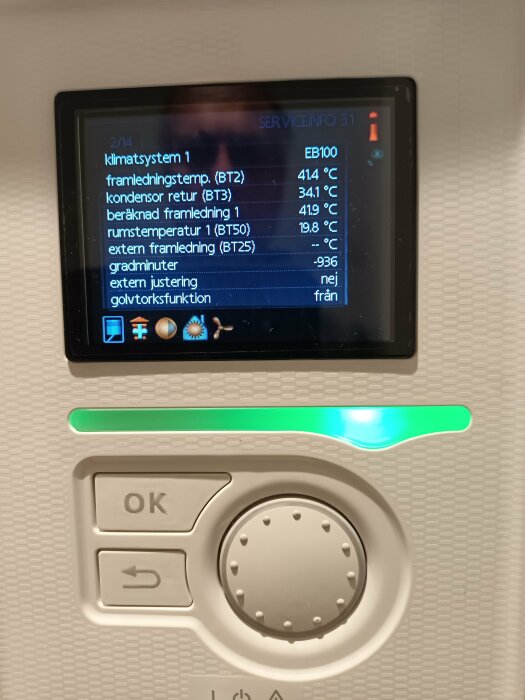 Digital display visar temperaturdata för klimatsystem. Kontrollpanel med OK-knapp och navigeringsknappsats.