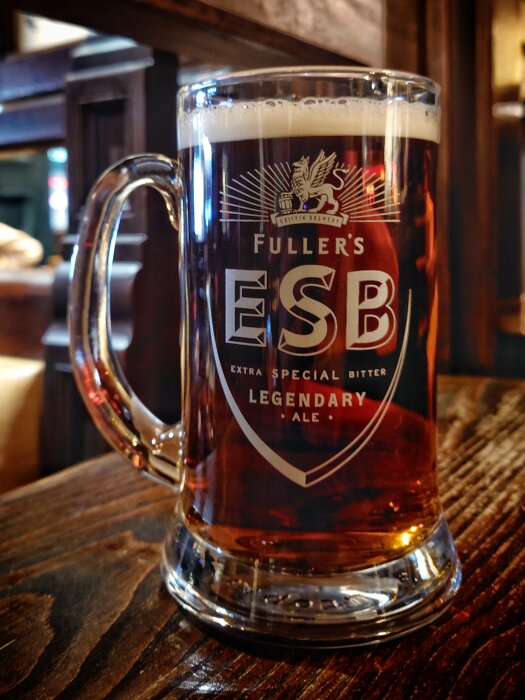 Ölsejdel med Fuller's ESB på en pub, skumkrona, genomskinlig, mörkt bärnstensfärgad dryck.