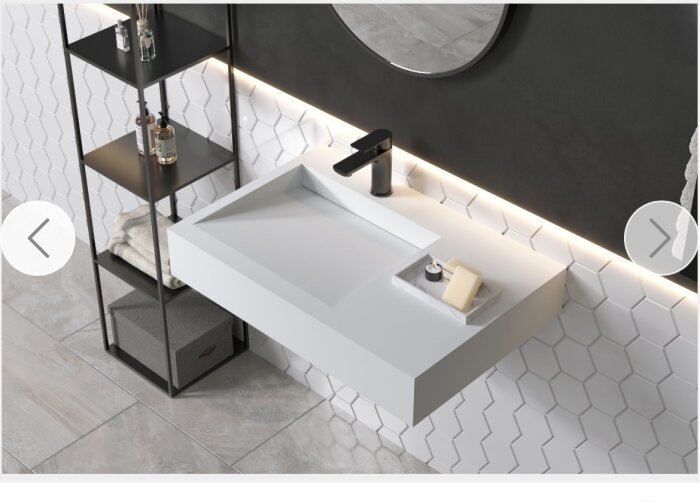 Modernt badrum, rektangulär handfat, svart kran, hexagonala kakel, hylla, handdukar, spegel, stilsäker design.