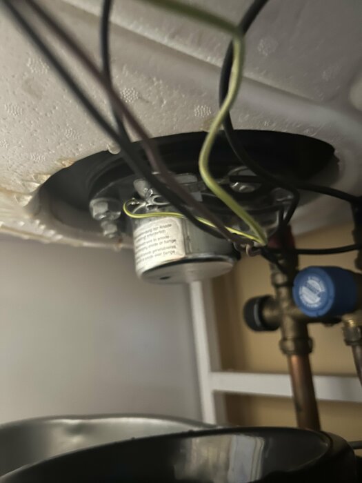 Belysningsarmatur demonterad, utsatta elektriska ledningar och takfäste, säkerhetsrisk, underhållsarbete, oordning.