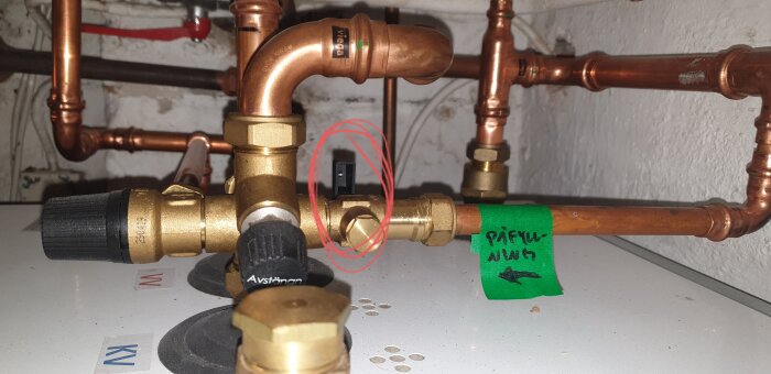 Ett system av kopparrör och ventiler, etikett med text, tegelvägg, avstängningsanordning, installation för vattenstyrning.