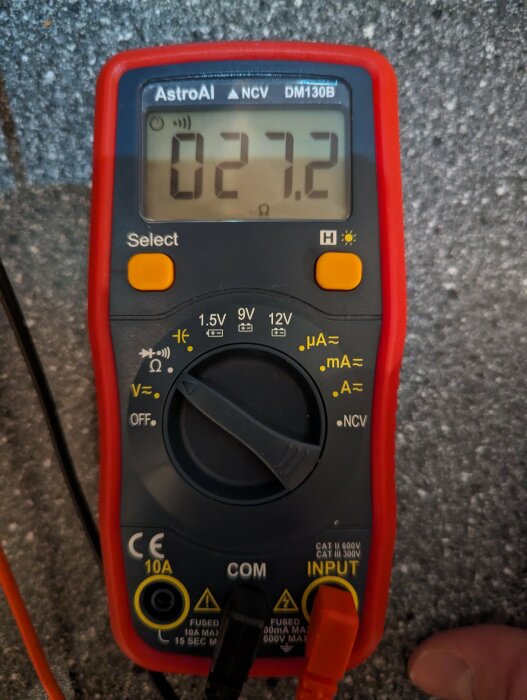 AstroAI multimeter visar 027.2, troligen spänning eller ström, orange och svarta mätprober anslutna, elektronikverktyg.