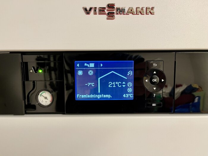 Värmepanna med digital display visar temperaturer och tryckmätare; modern uppvärmningsteknologi.