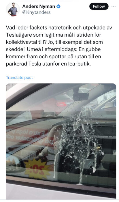 Bilfönster med spottloska, reflektion av ICA-skylt, diskussion om facklig retorik mot Teslaägare på Twitter.