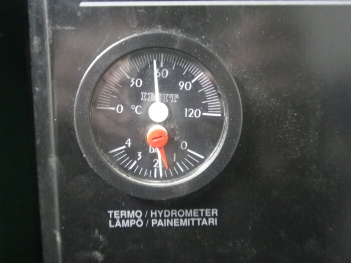 Termometer och hygrometer instrument, svart bakgrund, mäter temperatur och luftfuktighet, cirka 21 grader Celsius, 60% fuktighet.