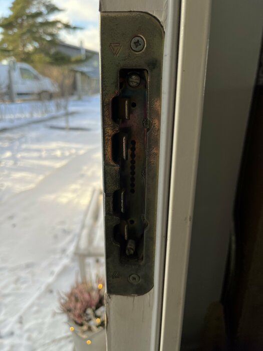 Fönsterlås närbild, vinterträdgård med snö bakgrund, hus, dekorationer synliga utanför.