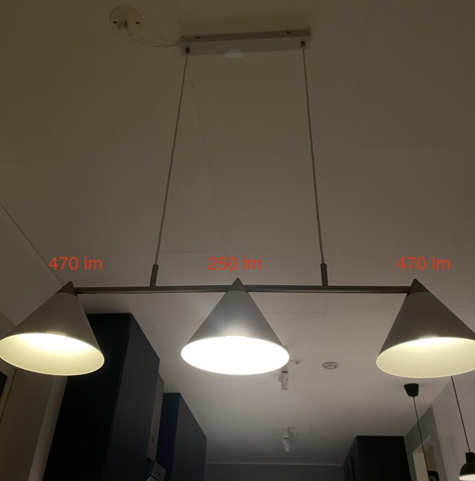 Två pendellampor i tak, upplyst, modern design, märkt ljusflöde (lumen), inomhusmiljö.