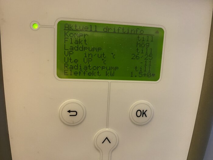 Display av värmepumpsdrift, visar temperaturer och effekt, två knappar för navigering, grönt ljus till vänster.