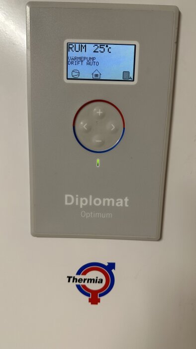 Termostat med display visar 25 grader Celsius, märkt "Diplomat Optimum", "Thermia", värmepumpsstyrning, automatisk drift.