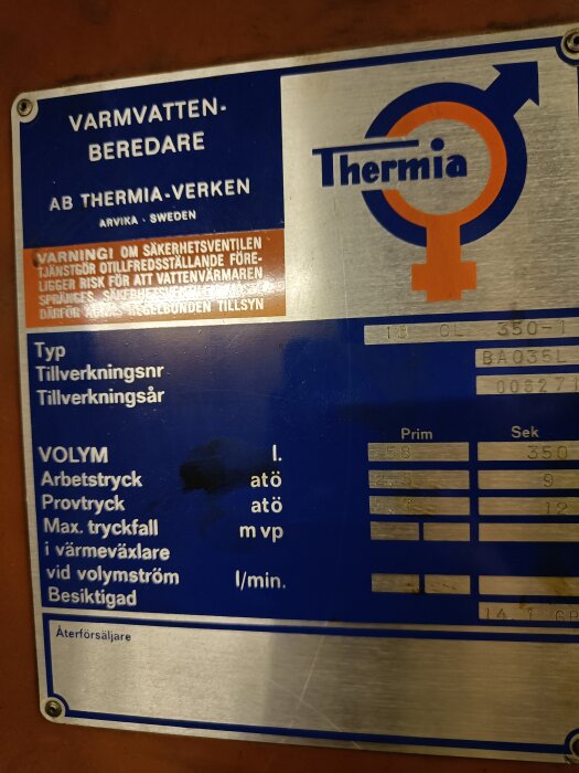 Informationsetikett på varmvattenberedare av märket Thermia. Tekniska specifikationer, varningar, och tillverkningsdetaljer på svenska.