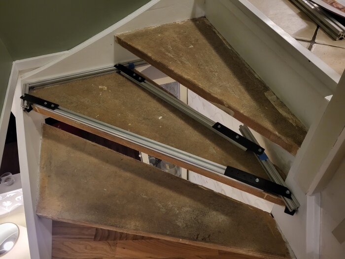 En trasig trappa med söndrade steg och hopvikt matallkonstruktion. Inomhus, slitsamt använd, behov av reparation.