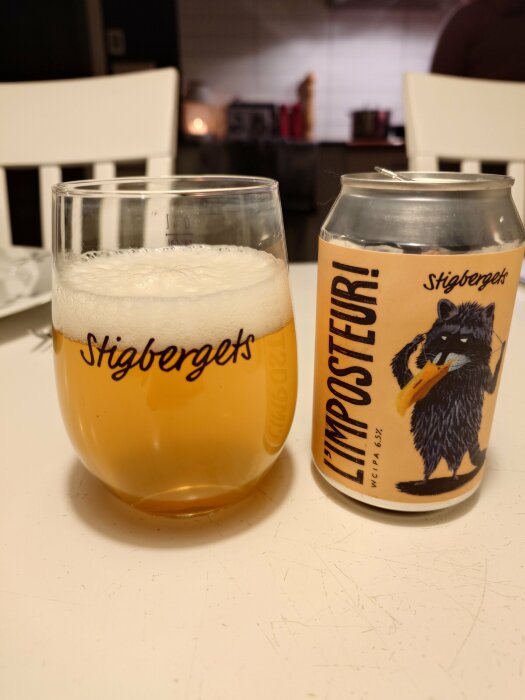 Öl i glas bredvid burk med etikett "IMPOSTEUR!" och illustration av fågel; märke "Stigbergets".