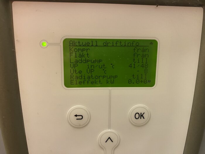 Digital display för uppvärmningssystem, visar driftinformation och temperaturer, knappar för navigering, lysande grön indikator.
