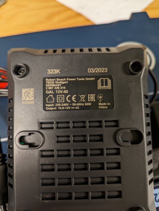 En batteriladdare från Bosch för elverktyg, informationsetiketter och specifikationer synliga, tillverkad i Kina.