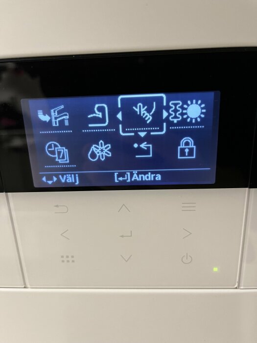 Digital display med ikoner för vitvarufunktioner, touchknappar under, modern teknologi, användargränssnitt.