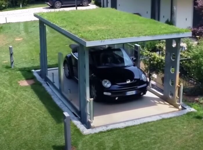 Ett svart fordon på en utomhus biltvättplattform med grönt tak.