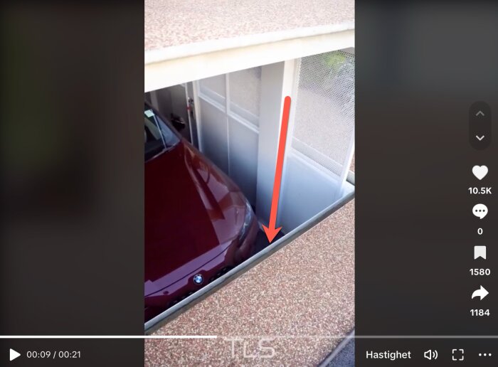 Video på en skärm visar bil som går genom en garageport, markering med röd pil.
