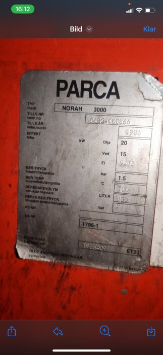 Slitet typskylt för PARCA NORAH 3000, med teknisk information och serienummer, mot röd bakgrund.