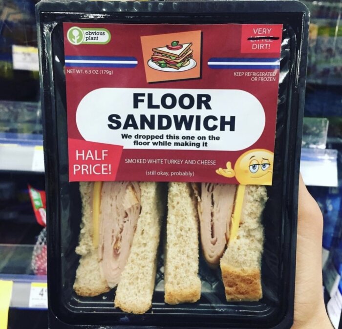 Förpackad smörgås märkt som "Floor Sandwich", humoristisk, halva priset, påstående om att ha tappats på golvet.