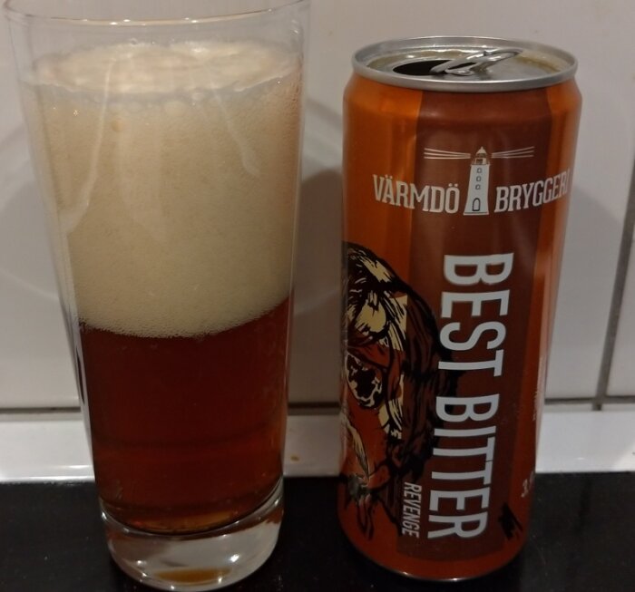 Ett glas öl bredvid en tom burk från Värmdö Bryggeri, märkt "Best Bitter".