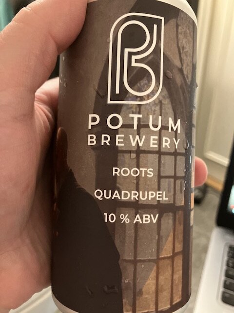 Burk från Potum Brewery, öl vid namn 'Roots Quadrupel', alkoholhalt 10%. Hand håller burken.