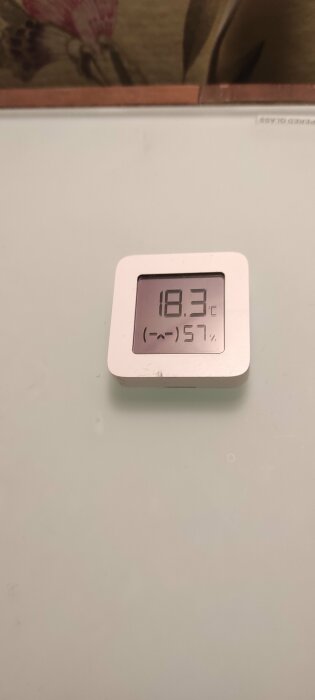 Digital termometer och hygrometer som visar 18.3°C och 57 % luftfuktighet.