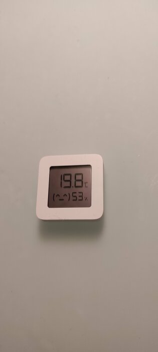 Digital termometer och hygrometer som visar 19.8 grader Celsius och 53% relativ luftfuktighet.