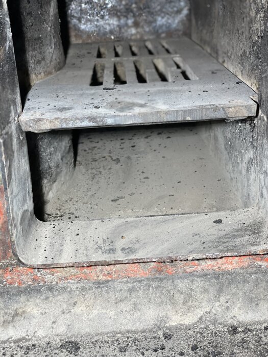 Grå metalltrappa i betongmiljö med smuts och slitage.