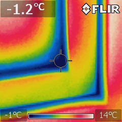 Termisk bild; färggradient visar temperaturskillnader; märken av mätinstrument; röd till blå spektrum; kallt till varmt.