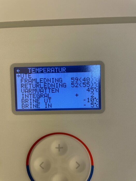 LCD-skärm som visar temperaturinformation, eventuellt för en värmepump, med justeringsknappar nedanför.