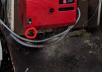 Röd generator med elkabel, markerat område, industriell miljö, nedgången bakgrund.