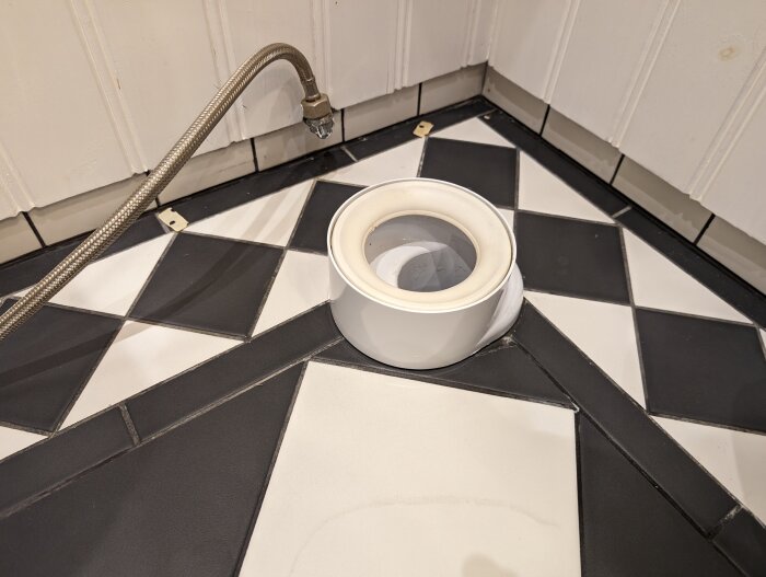 Toalettsits på schackrutigt golv, duskslang, vit och svart, element, enkel miljö.